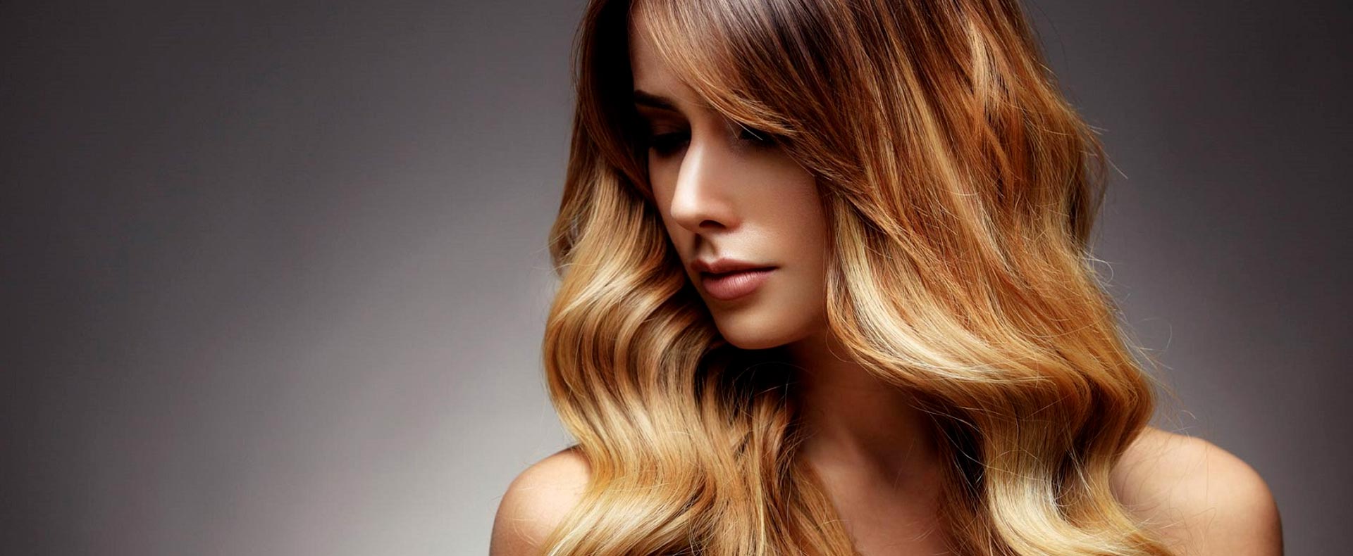 Hier zu sehen ist eine Frau mit gewellten Haaren im Ombre Look- Friseur Hair&Style Altbach