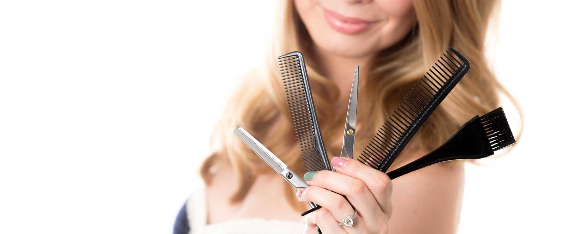 Hier zu sehen ist eine Frau, die Scheren, Kämme und Färbepinsel in der Hand hält | Friseur Hair&Style Altbach