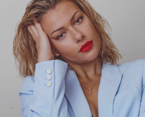 Hier zu sehen ist eine Frau in einem Blazer, die Sleek Back Hair als Frisur für fettige Haare trägt | Tipps gegen fettige Haare - Hair&Style Altbach